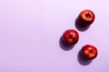 Many red apples on colored background, top view. Autumn pattern with fresh apple above view with copy space for design or text