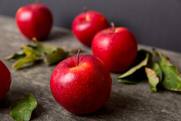 Fresh red apples with green leaves on wooden table. On wooden background. Top view free space for text