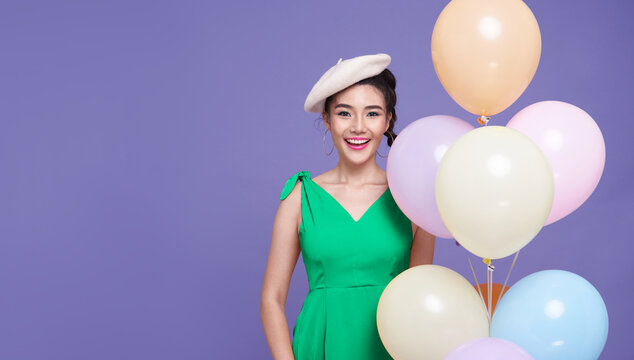 Pretty young asian woman at celebration party holding colourful balloon and excited face with copy space. Happy new year or Birthday  celebrating concept.