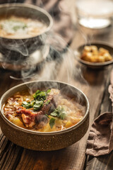 Hot steaming pea soup on a wooden background.
