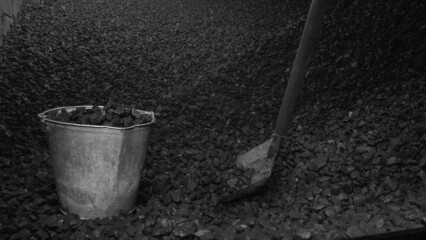 Fototapeta premium A pile of brown coal, a bucket of coal and a shovel. Fuel for heating in winter