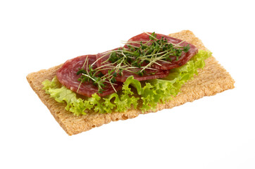 Variety of mini sandwiches with cream cheese, vegetables and salami.