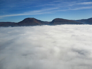 Fototapeta na wymiar Fog over city, mountains, sky, sunny
