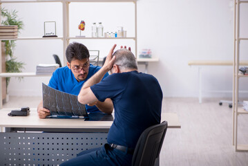Old man visiting young male doctor radiologist