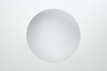 Minimalist white background. Circular cut-out hole in the paper.