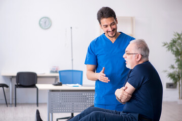 Fototapeta premium Old man visiting young male doctor
