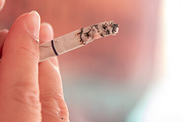 Person smoking a cigarette on a blurred background