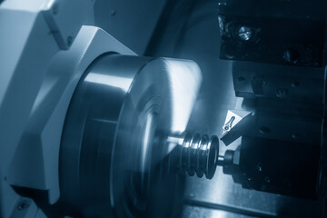 The  CNC lathe machine groove cutting the metal pulley parts.