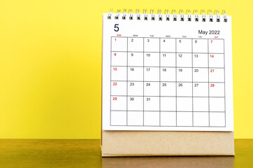 The May 2022 desk calendar with yellow background.