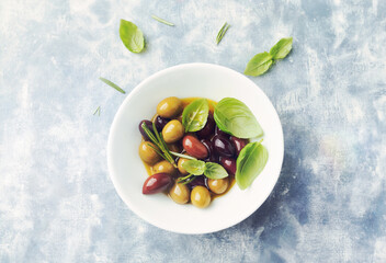Green and kalamata olives on bright wooden background. Top view. Copy space. 