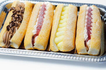 Mixed finger donuts filling chocolate, custard, jam and whipped cream, eclairs in different flavors