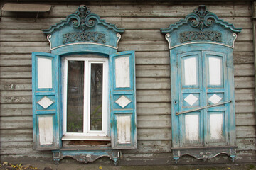 Wooden architecture of Siberia, old Windows with wooden carved architraves. old peeling paint on...
