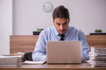 Young male employee and too much work in the office