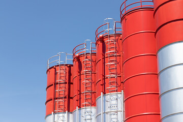 red and silver steel silos. metal silos for concrete mix process plant.