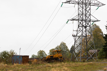 Russia. Adygea. Abandoned construction equipment near the power line.