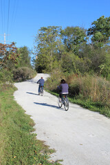 Fototapeta premium Man and woman riding bicycles on the Illinois and Michigan Canal State Trail in Lemont