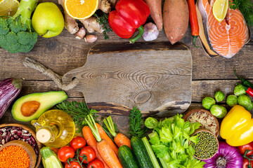 Healthy food background. Fresh vegetables, fruits, beans, meat and fish on wooden table. Healthy balanced food, dieting and healthy eating concept. Top view