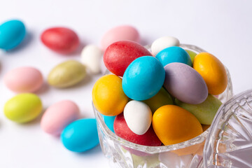 Colorful almond candies in the stylish,crystal candy bowl on white with copy space.The Sugar Feast concept. (Turkish name; Ramadan - Ramazan bayrami, Seker bayrami)