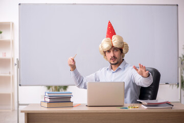 Funny young male teacher magician in the classroom