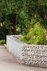 A small wall made of stones embedded in a wire cage.