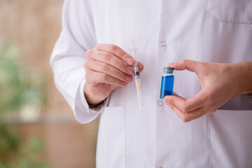 Young male doctor in vaccination concept