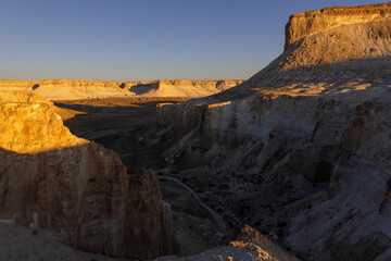 Sunrise over the sheer cliffs and limestone mountains of Bozjyra (or Boszhira). Ustyurt Plateau, Mangystau region, Kazakhstan.