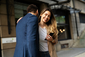 Young businesswoman and businessman standing on the street Beautiful businesswoman talking with her colleague.