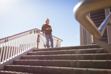 Thoughtful albino african american man with dreadlocks wearing headphones using smartphone