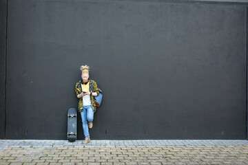 Thoughtful albino african american man with dreadlocks using smartphone