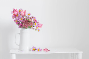 pink flowers in white jug on background  white wall