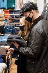 Naklejka premium Black friday pandemic concept. Young couple in black masks at the mall