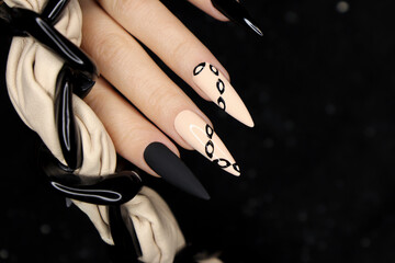 Beige and black manicure on long nails.