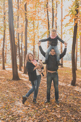 Fototapeta premium Family spend time in autumn park with a dog. Father, mother and daughter and jack russell terrier dog having fun in fall