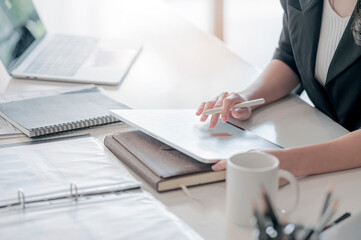 woman hands holding stylus pen and touching on tablet screen.