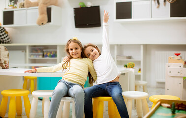 Two best friend girls together in the nursery playroom