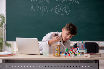 Schoolboy studying chemistry in the classroom