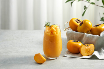 Front view of a tray with persimmon and persimmon frappe , green leaf in white curtain background for food advertising 