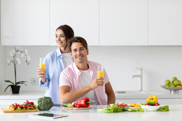 Happy young couple in love preparing healthy meal in kitchen.