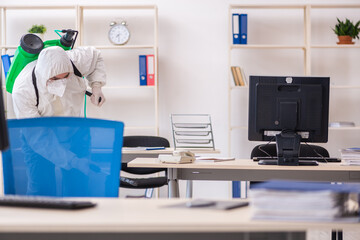 Old male contractor in office disinfection concept