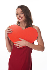 Portrait of cheerful young Caucasian woman with red lips hugging heart while finding her valentine
