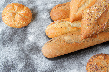 fresh baguettes with crispy crust, spices and seeds, spread on the table with a sprinkle of wheat flour.