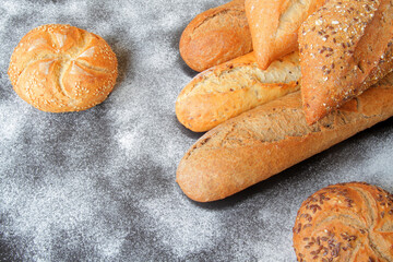 fresh baguettes with crispy crust, spices and seeds, spread on the table with a sprinkle of wheat flour.