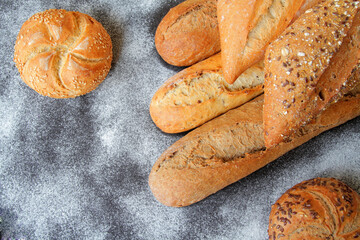 fresh baguettes with crispy crust, spices and seeds, spread on the table with a sprinkle of wheat flour.