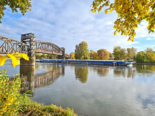 historische Eisenbahnbrücke Magdeburg im Herbst mit Schubschiff