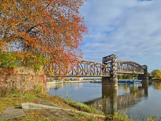 historische Eisenbahnbrücke Magdeburg im Herbst mit Schubschiff