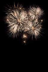 Fireworks display isolated on black with copy space. Pyrotechnic background for greeting card or festival celebration poster. Vertical format