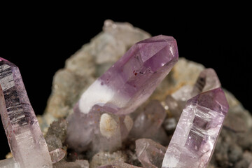 Macro mineral stone Amethyst crystals in rock on a black background