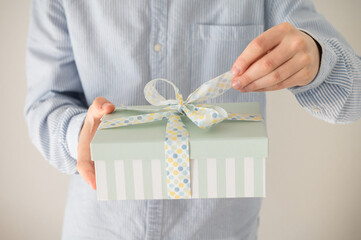 Photo of beautiful gift box in boy's hands at new year holidays or birthday celebration