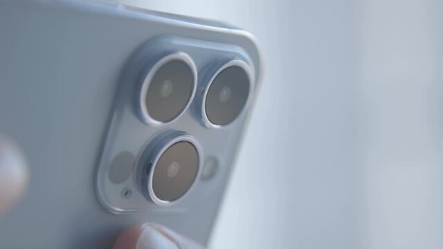 Filming video clip with Iphone 13 Pro mobile phone device with three camera lenses. Modern smartphone with triple camera shoots 4K footage