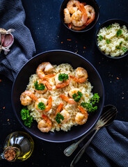 Risotto with prawns, chili and parsley on wooden table

